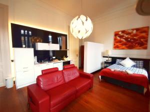 uma sala de estar com um sofá vermelho e uma cama em Maison Jamaer em Bruxelas