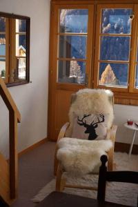 a living room with a chair and windows at Vue à couper le souffle Arellaz 42 in Zinal