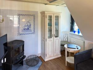 a living room with a wood stove in it at Friesenhof, Haus Hafis, Whg 9 in Nebel