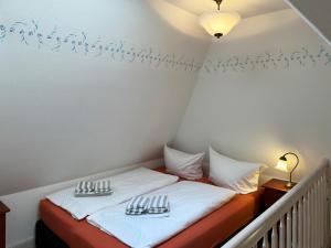 a room with a bed with two plates on it at Friesenhof, Haus Hafis, Whg 9 in Nebel