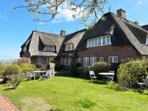 an old house with a thatched roof and a yard at Friesenhof, Haus Hafis, Whg 9 in Nebel