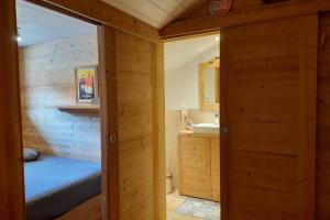 a bathroom with a bed and a sink in a room at Apartment in the center of the village in La Clusaz