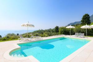 una grande piscina con sedie e ombrelloni di Ca Bianca Zero by Garda FeWo a Toscolano Maderno