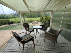 een afgeschermde veranda met stoelen en een tafel bij Inviting bungalow in Gelderland with garden in Garderen