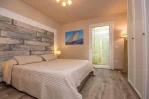 una camera da letto con un letto e un muro di pietra di Ca Bianca Zero by Garda FeWo a Toscolano Maderno Altre 27 foto