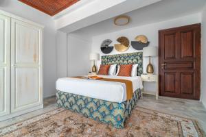 sypialnia z dużym łóżkiem i drewnianymi drzwiami w obiekcie Megaron Skiathos Boutique Residence w mieście Skiatos