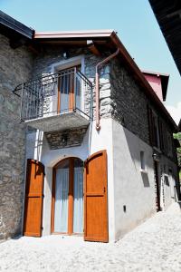a building with wooden doors and a balcony at La Stalletta in Menaggio