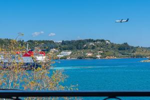 a plane flying over a body of water at Megaron Skiathos Boutique Residence in Skiathos