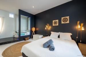 a bedroom with a large white bed with blue towels on it at LOFT Design Jacuzzi Centre Gare - Parking gratuit in Toulouse