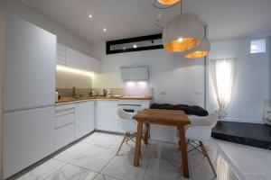 a kitchen with a wooden table and white cabinets at LOFT Design Jacuzzi Centre Gare - Parking gratuit in Toulouse