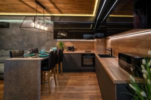 une cuisine avec un comptoir et un îlot de cuisine avec des chaises dans l'établissement Apartment Luxury Vision, à Varna