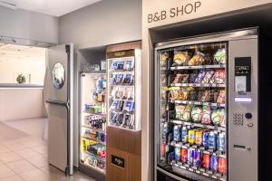 a refrigerator in a store with food and drinks at B&B HOTEL Madrid Aeropuerto T1 T2 T3 in Madrid