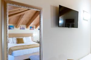 a mirror in a bedroom with a bed and a tv at Hotel Autoespresso Venice in Marghera