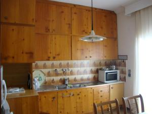 a kitchen with wooden cabinets and a sink and a microwave at Village Apartment 