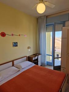 una camera con un grande letto e un balcone di HOTEL CLARA RIMINI 30m from the beach a Rimini