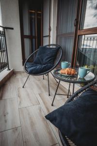 a balcony with a chair and a table with food on it at Apartment Luxury Vision in Varna City