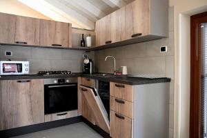 a kitchen with wooden cabinets and a sink and a microwave at La Stalletta in Menaggio