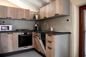a kitchen with wooden cabinets and a sink and a microwave at La Stalletta in Menaggio +18 photos