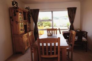 a dining room with a table and chairs and a window at House Located at the centre of East Auckland walking to Botany Westfield Shopping Mall in Auckland