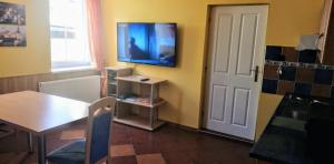um quarto com uma mesa e uma televisão na parede em penzion U Soudu em Liberec