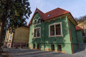 a green house with a red roof at Interbelic vibe in Cluj-Napoca