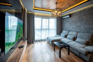 a living room with a couch and a flat screen tv at Apartment Luxury Vision in Varna City