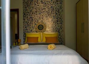 1 dormitorio con 1 cama grande con almohadas amarillas en Guesthouse Lion, en Split