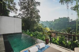 a swimming pool on a balcony with a view of the mountains at Amora Ubud Boutique Villas in Ubud