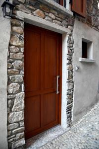 a wooden door on the side of a stone building at La Stalletta in Menaggio