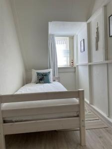 a small bedroom with a bed and a window at Voilà! - beach at 500m- free parking in Noordwijk aan Zee