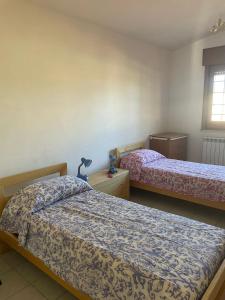 a bedroom with two beds and a window at Sans-souci in Nardò