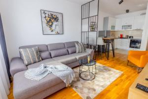 ein Wohnzimmer mit einem Sofa und einer Küche in der Unterkunft Platinum_Luxury_Apartment in Teslić