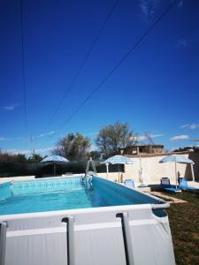una piscina in un cortile con ombrelloni di Villa Jolie ad Augusta