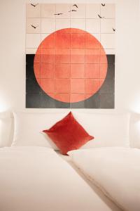 sypialnia z białym łóżkiem i czerwoną poduszką w obiekcie Italyescapes Delia w Meranie