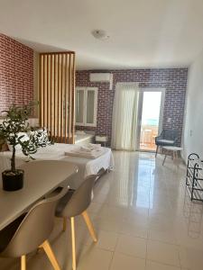 Nautica Hotel Apartments في Stavromenos: غرفة طعام مع طاولة وكراسي وغرفة بها