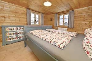 two beds in a bedroom with wooden walls at s'batlogg8 in Schruns