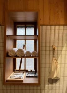 a bathroom with a shelf with towels and a window at Spring12 House in Chiayi City +37 photos