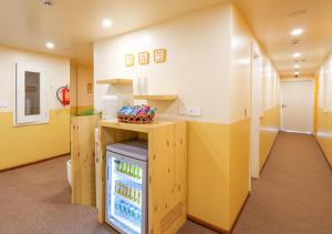 a room with a refrigerator in a room with yellow walls at Bloom Hotel - Golf Course Road, Sector 43 in Gurgaon