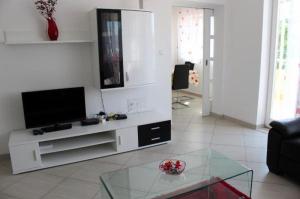 a living room with a tv and a glass table at Apartment in Zaboric with sea view, balcony, air conditioning 5178-3 in Šibenik