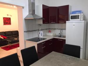 a kitchen with a refrigerator and a table with chairs at Apartment in Zaboric with sea view, balcony, air conditioning 5178-3 in Šibenik