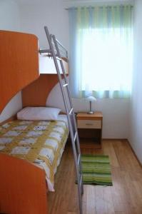 a bunk bed with a ladder in a room at Apartment in Zaboric with sea view, balcony, air conditioning 5178-3 in Šibenik