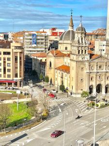 una ciudad con un edificio y una calle con coches en APARTAMENTO CENTRO GIJÓN con WIFI gratis y PARKING PÚBLICO próximo incluido, en Gijón