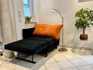 バンシンにあるVilla Marfa - FeWo 03の黒いベンチ(オレンジの枕付)