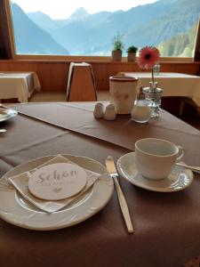 a table with a plate and a cup on it at Alpenpension Maderer in Gaschurn