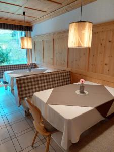 a dining room with a table and a bath tub at Alpenpension Maderer in Gaschurn