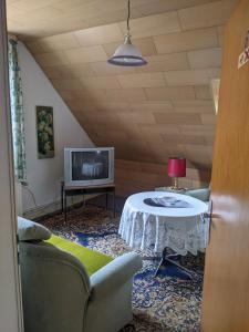 uma sala de estar com uma mesa e uma televisão em Pension Haus Martha em Bad Grund