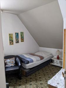 ein Schlafzimmer mit einem Bett und einem Sofa in einem Zimmer in der Unterkunft Pension Haus Martha in Bad Grund