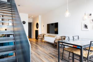 - un salon avec une table à manger et une télévision dans l'établissement Loft-Style Duplex with Balcony in Downtown Reykjavík, à Reykjavik