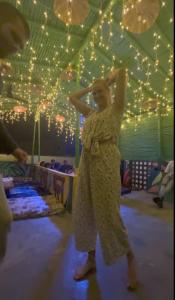 a woman standing on a dance floor with her arms in the air at Madsquad Varanasi - Dorms & Rooms in Varanasi