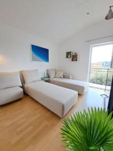 ein Wohnzimmer mit 2 Sofas und einem großen Fenster in der Unterkunft Villa Porto in Rogač